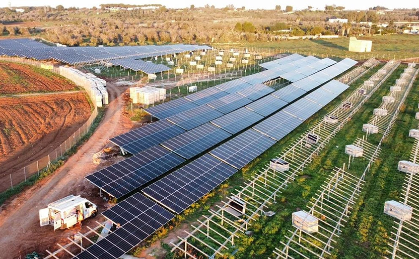 Zu sehen ist der Bau der Photovoltaik Anlage in Novoli Italien aus der Vogelperspektive. Links ist ein Montageauto auf einem Feldweg zu sehen. Vorne Links sieht man Gerüste für die PV Platten.